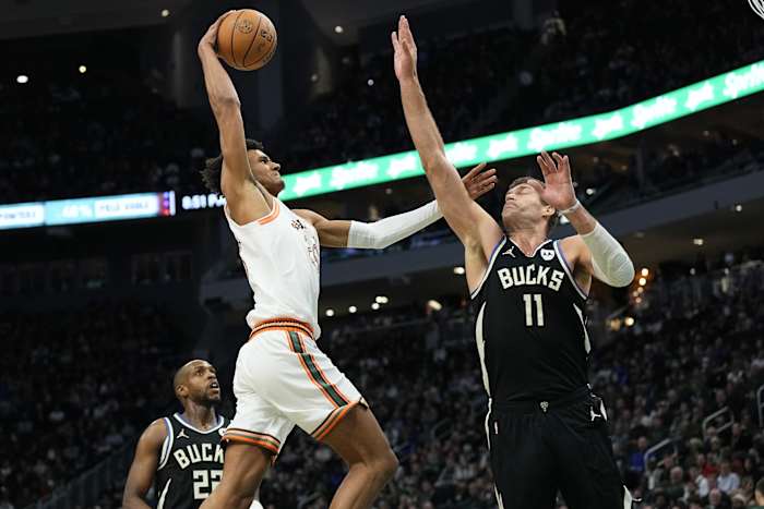 San Antonio Spurs forward Dominick Barlow (26) drives for a shot against Milwaukee Bucks center Brook Lopez (11)